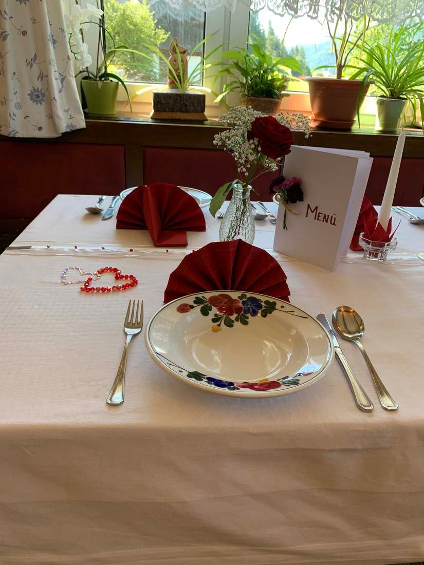 Festlich gedeckter Tisch mit Serviette und Blumenschmuck