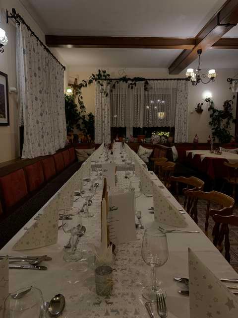 Lange, weiß gedeckte Festtafel in der Gaststube
