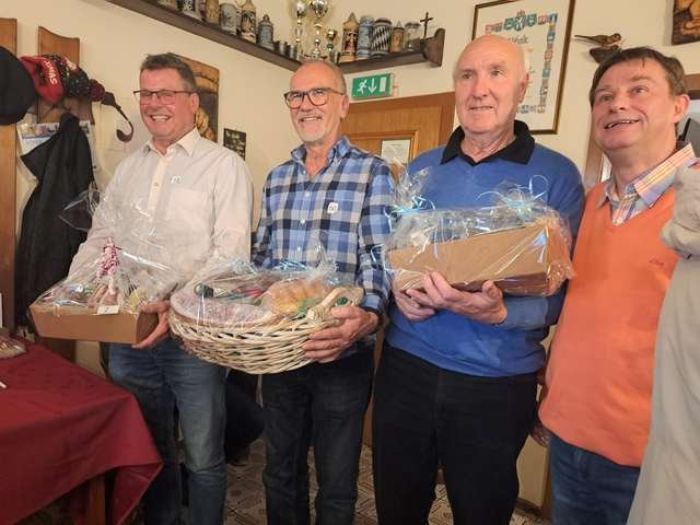 Die Sieger eines Schnapsturniers mit ihren Preiskörben