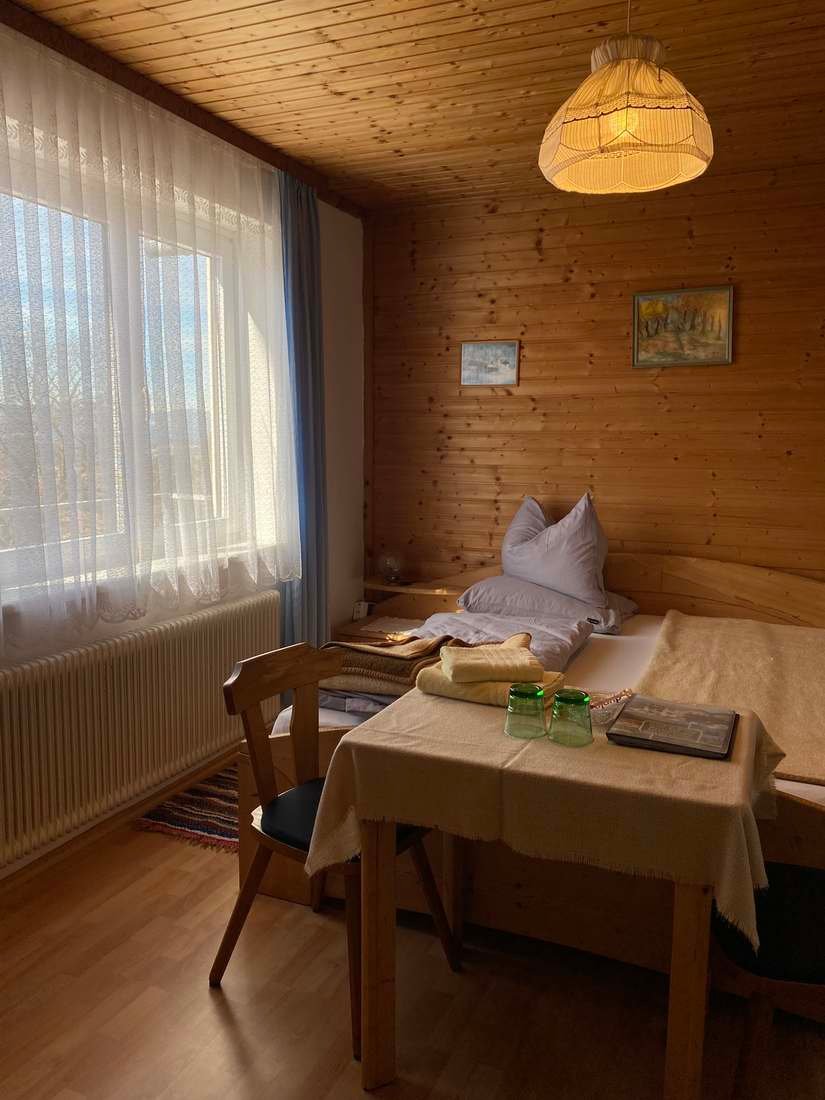 Gemütliches Gästezimmer mit Tisch und Stuhl